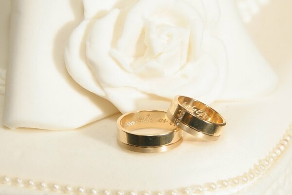 Anillos de boda con adornos y flores blancas