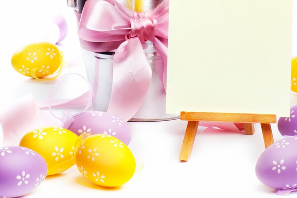 Purple and yellow eggs are lying near a small easel