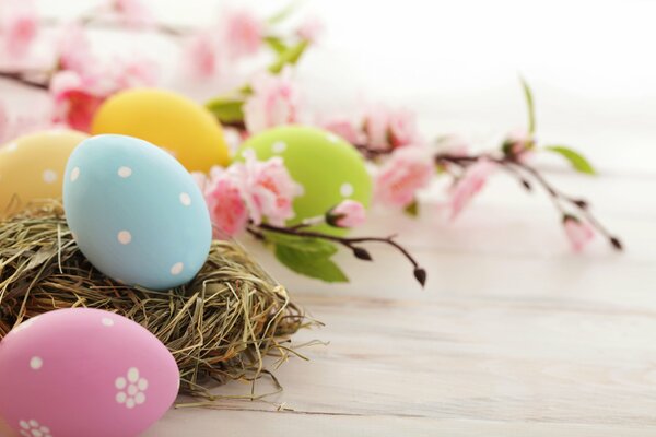 Huevos de Pascua de diferentes colores yacen junto a una rama