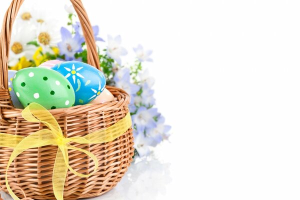 Uova di Pasqua colorate giacciono in un cesto di vimini