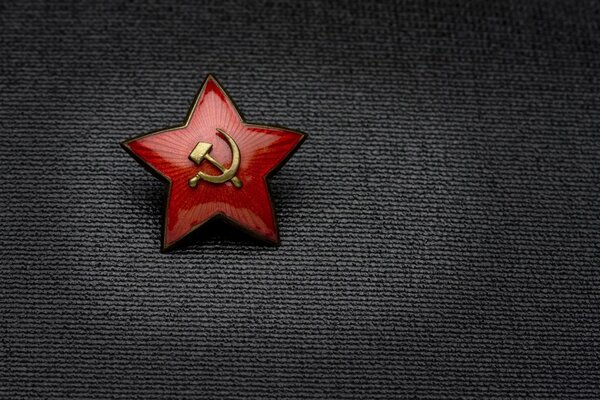 Order in the form of a red star inside a hammer and sickle on a black background