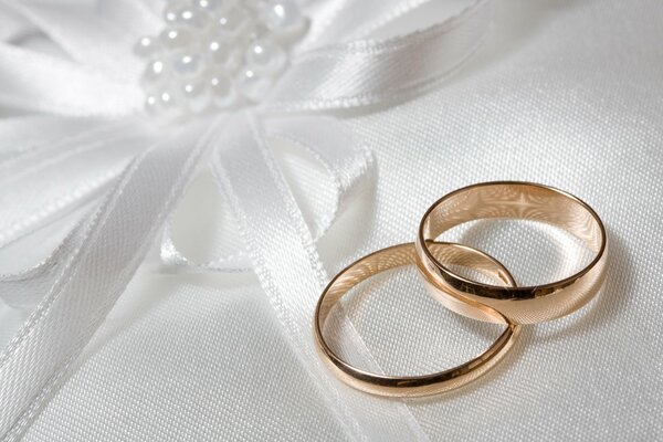 Two wedding rings on white fabric