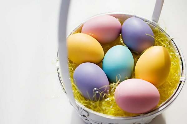 Ostern gefärbte Eier in einem Korb auf weißem Hintergrund