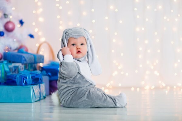 Bambino in costume da coniglietto all albero di Natale