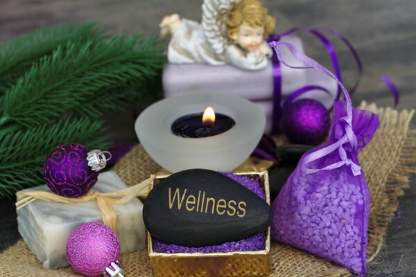 Stone for massage on the background of a fir branch, an angel and Christmas balls