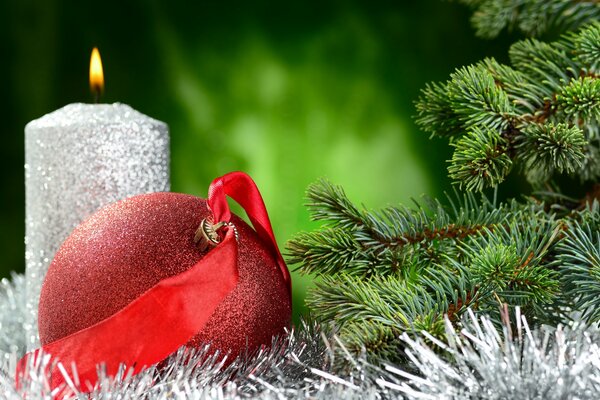 Silver candle with a red ball at the Christmas tree