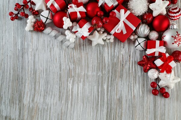 Juguetes de Navidad y cajas de regalo sobre un fondo gris