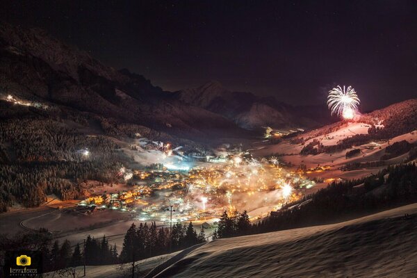 Ciudad nocturna de invierno con luces y fuegos artificiales