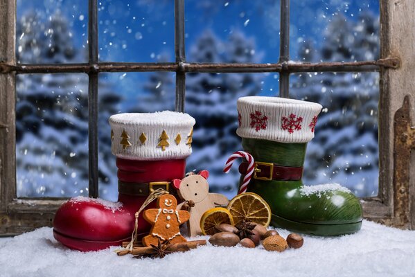 Weihnachtsmann-Schuhe und Weihnachtsdekor auf Fensterhintergrund