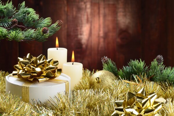 Горящие свечи и подарок украшенный золотой лентой