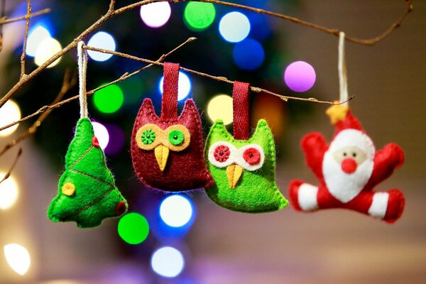 Búhos verdes y rojos con un árbol de Navidad y Santa Claus en una rama