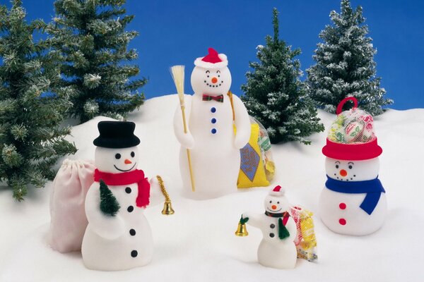 Familie der Schneemänner auf dem Schnee auf dem Hintergrund der Weihnachtsbäume