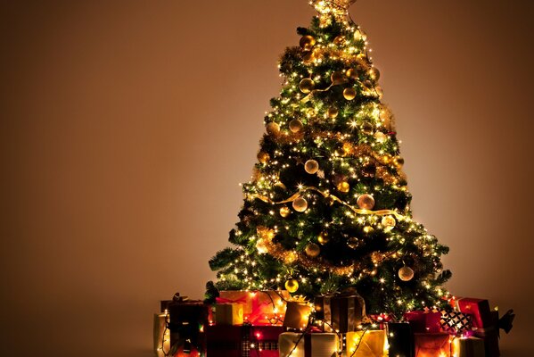 Los juguetes brillantes cuelgan del árbol de Navidad. Regalos esperando a los chicos