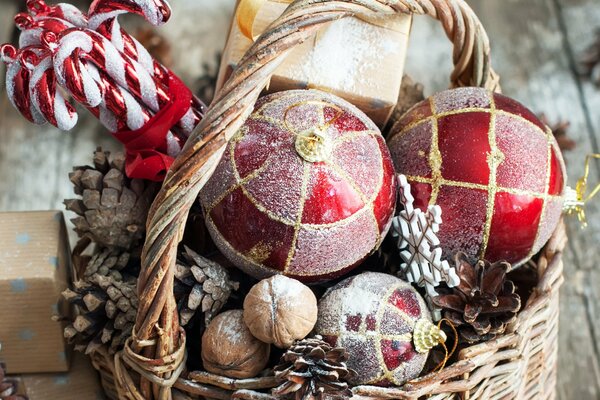 Weihnachtsspielzeug im Korb. Christbaumkugeln und Zapfen