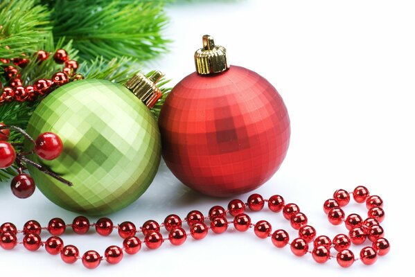 Two Christmas balls next to the branches of a fir tree