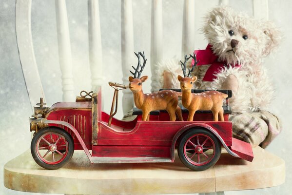 En una silla, un oso de peluche se sienta en un coche