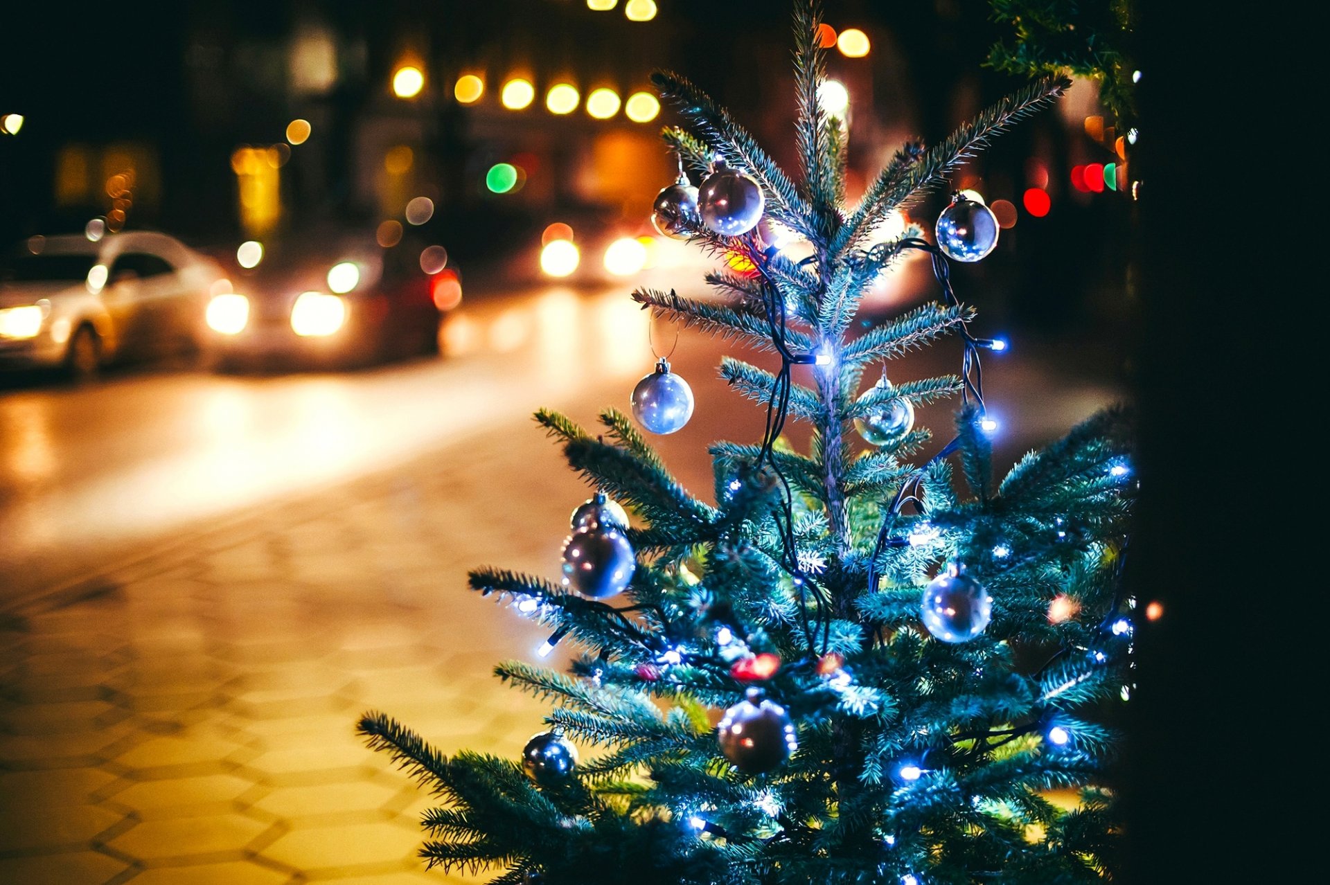 abeto árbol de navidad guirnaldas ramas bolas árbol de navidad juguetes luces bokeh ciudad noche calle carretera coches acera invierno vacaciones año nuevo navidad