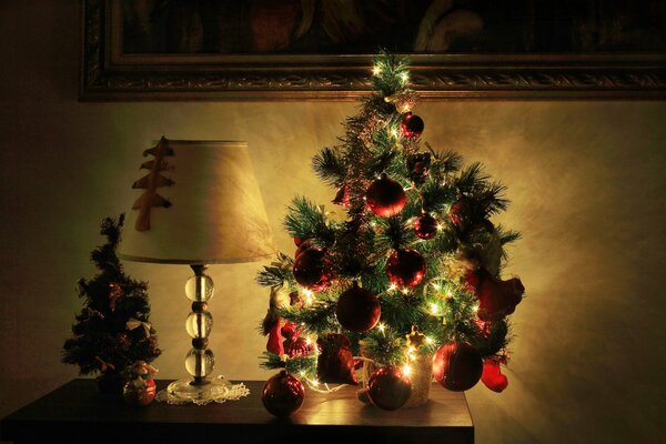 Weihnachtsbaum in Lichtern im Zimmer auf dem Nachttisch