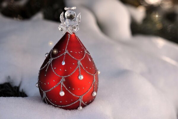 Rotes Weihnachtsbaum-Spielzeug mit Engel im Schnee