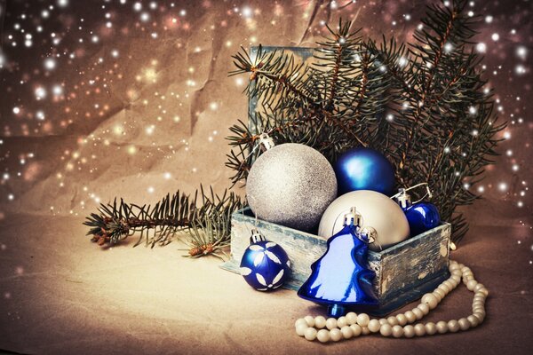 A box with Christmas balls and spruce twigs