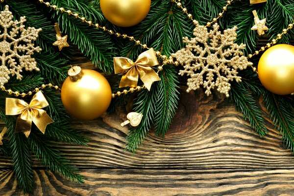 Gold snowflakes, balls and bows on a fir branch