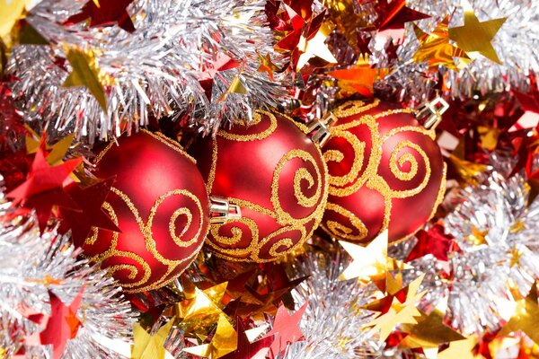 Una meshura argentata e soffice con stelle incornicia le tre sfere dell albero di Natale in motivi