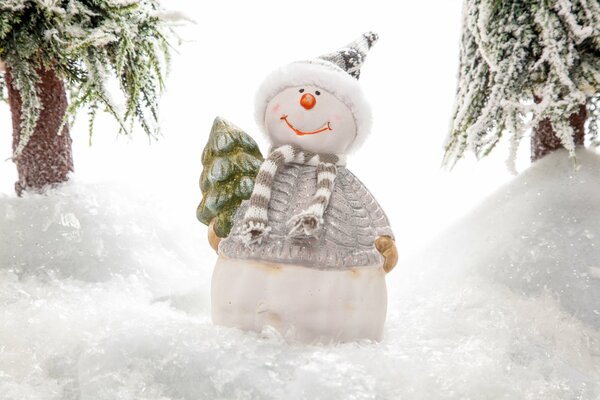 Pupazzo di neve elegante con un albero di Natale dietro la schiena