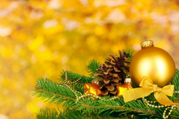 Spruce paw with Christmas decorations on a yellow background