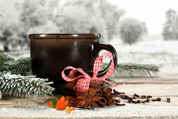 Winter still life with cup, ribbon and cinnamon