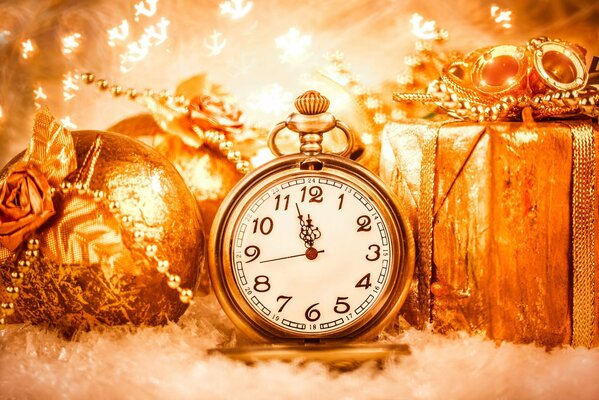 Kupfergoldschmuck aus Rosenkugeln und Geschenk und drei Minuten vor Neujahr auf der Uhr