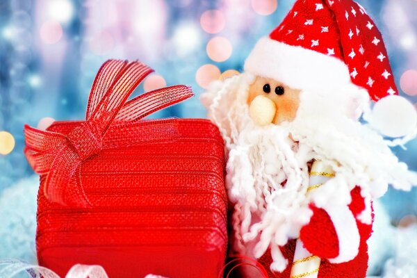 Santa Claus toy with a gift on the background of lights