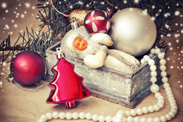 Debajo del árbol de Navidad hay una doncella de nieve en una Caja, bolas, un juguete de árbol de Navidad y cuentas blancas