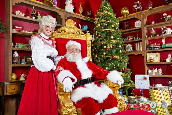 Santa Claus en el trono rojo con regalos de árbol de Navidad