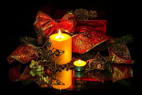 Burning candles with a red festive ribbon