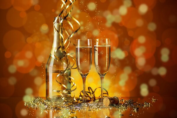 A bottle and two glasses of champagne in the middle of New Year s tinsel