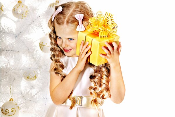 Ragazza con riccioli e fiocchi con un regalo di Capodanno