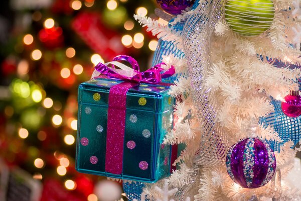 Toys in the form of gift boxes and balls look very festive on the Christmas tree