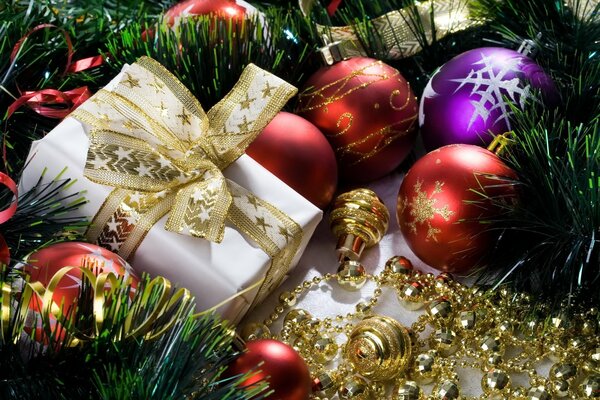 Regalo che giace tra i giocattoli dell albero di Natale