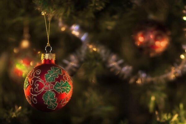 El juguete rojo de la Navidad con el patrón cuelga en el árbol de Navidad