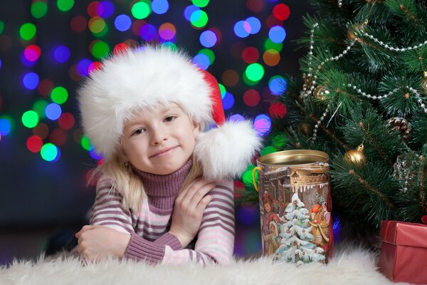 A girl in a fur hat at the Christmas tree