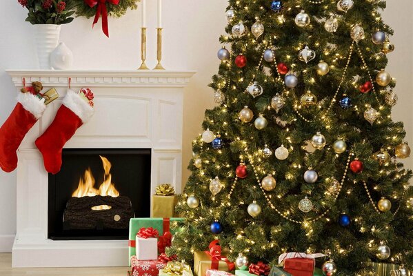 Árbol de Navidad junto a la chimenea en llamas