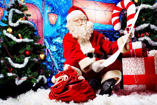 Święty Mikołaj z prezentami przy choince