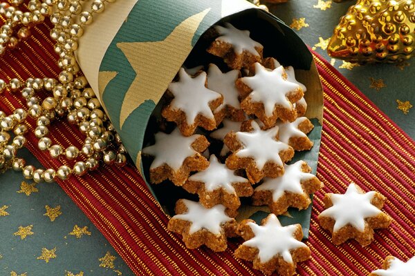 Christmas cookies with icing surrounded by gold beads