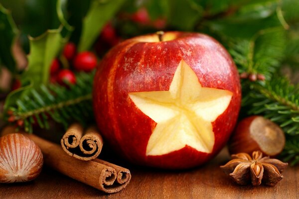 Manzana con forma de estrella cortada y canela cerca del árbol de Navidad