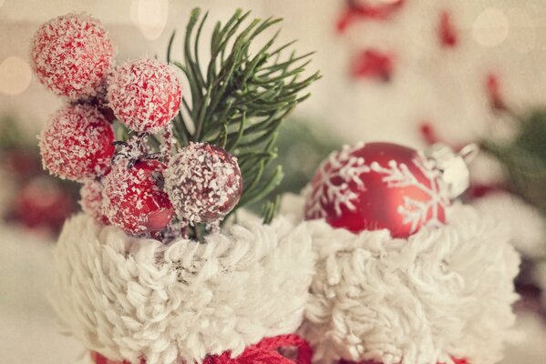 Stivali rossi e bianchi per Natale decorati con bacche, un ramoscello e una palla