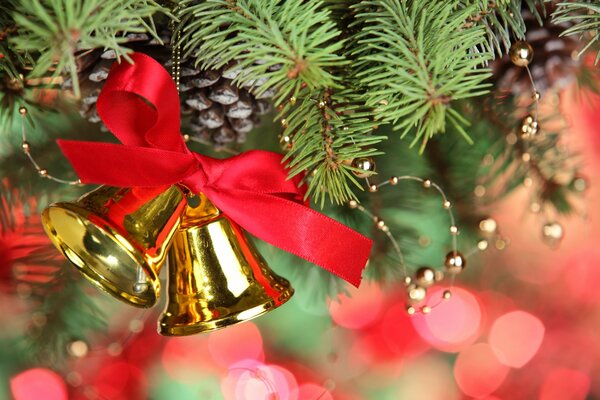 Decoration golden bells with a red bow on the Christmas tree