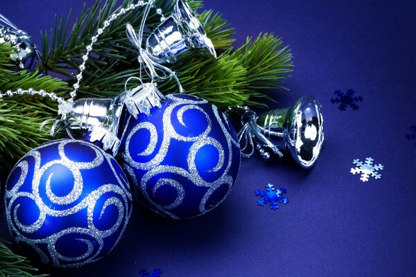 Due palline blu di Capodanno con riccioli d argento su un ramo di abete rosso