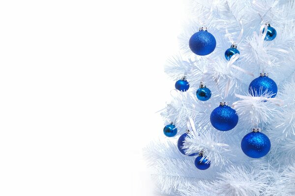 Blaue Kugeln auf einem schneeweißen Weihnachtsbaum