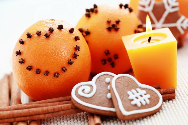 Año nuevo pan de jengibre, naranjas, canela y vela encendida