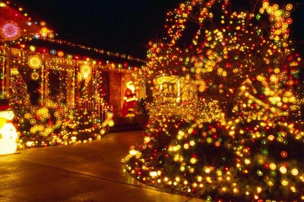 The night city is decorated with a Christmas tree and garlands